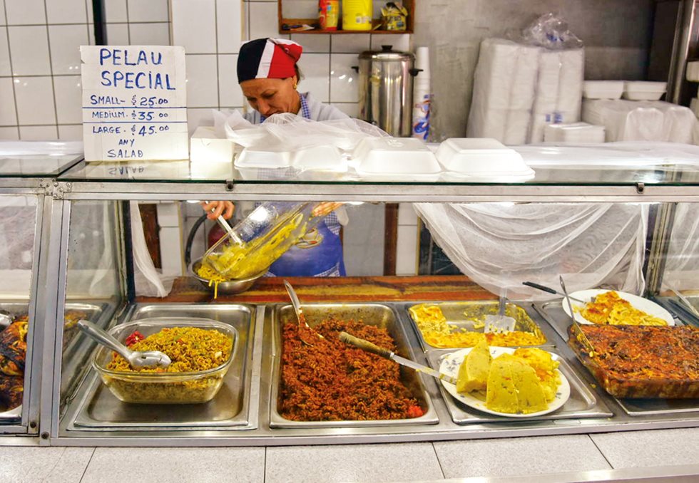 <p>An informal café sells three serving sizes of pelau, the Trinidadian favorite that plays off Indian biryani but is browned in syrup in an African style and seasoned with Trinidadian “green seasoning,” hot pepper and coconut milk.</p>