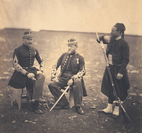 <p>In a photo taken in 1855 during the Crimean War, a Zouave in full dress stands next to French officers. By that time, the Zouaves were almost entirely members of the regular French Army in uniforms based on the original North African Zouaves, of whom just a handful by then served, usually as interpreters.</p>
