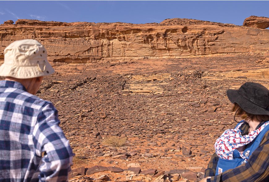 Melissa Kennedy of the University of Western Australia and the author examine the outlines of the same mustatil from ground level, where its parallel lines pointing toward the cliffs are barely distinguishable. 