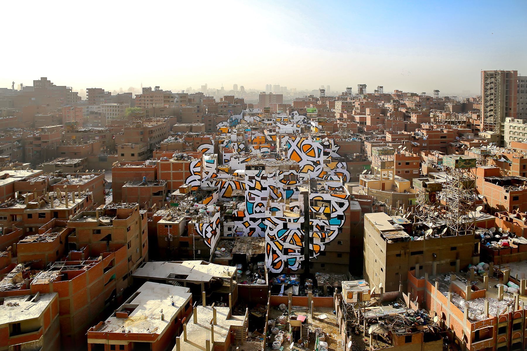 In his most complex calligraffiti project to date, eL Seed spent much of 2016 painting more than 50 buildings in Cairo to create &ldquo;Perception.&rdquo; It translates: &ldquo;Anyone who wants to see the sunlight clearly must first wipe his eyes&rdquo;&mdash;words visible in full only from a single vantage point.