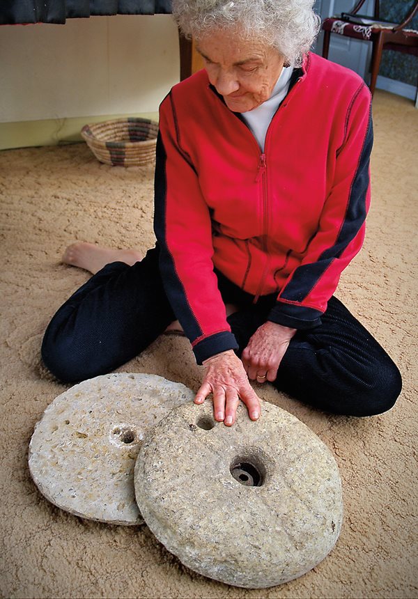 <p>Among Elinor Nichols’s donations was this pair of limestone grinding stones. The indentation near her finger held a wooden handle used to turn the top stone against the lower one. “We enjoyed looking at them around our home,” says Nichols. “As time passed, I realized they should all be returned.”</p>