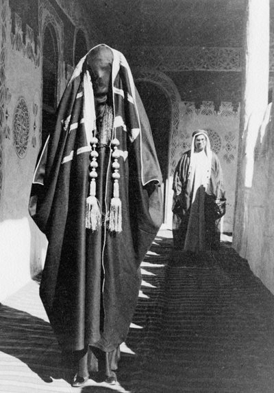 In Riyadh, George photographed Geraldine in ceremonial attire at the newly built Badi`ah palace. In the background stands Shaykh Hafiz Wahba, Saudi Arabia’a representative in Britain. 