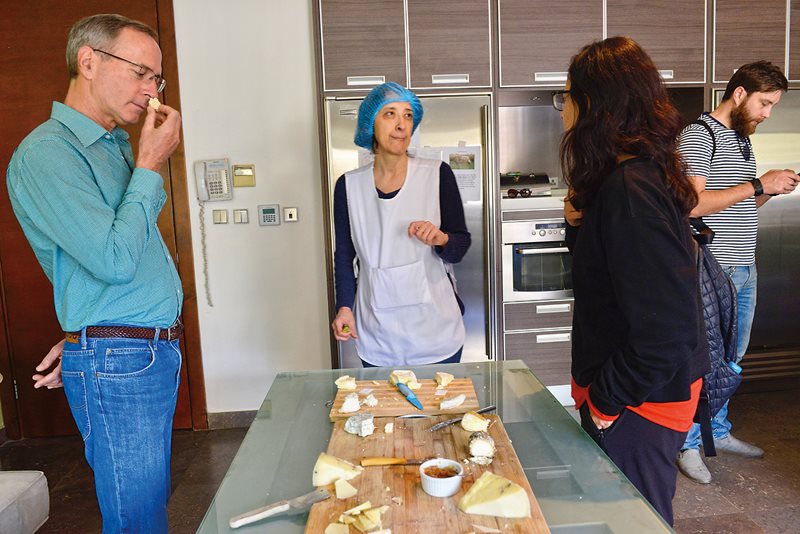 Visitors and prospective customers sniff, eye and taste cheeses by Jordanian artisan cheesemaker Nisreen Haram.