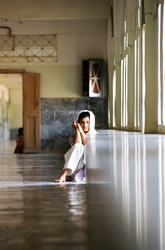 A schizophrenic patient chooses the shade of a corridor of the North Karachi Center.