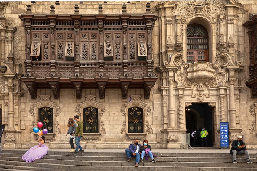 Backdrop for countless photos in the historic center of Lima, a young  woman poses beneath one of the city’s most famous balcones de cajón, or box balconies, that of the Palace of the Archbishop. Photo by Mariana Bazo.