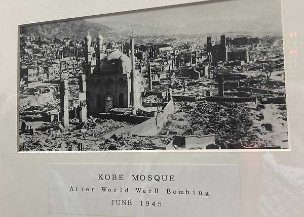 On display in the lobby of Kobe Mosque, a photo shows the mosque standing amid the destruction of the city during a bombing in World War II. 