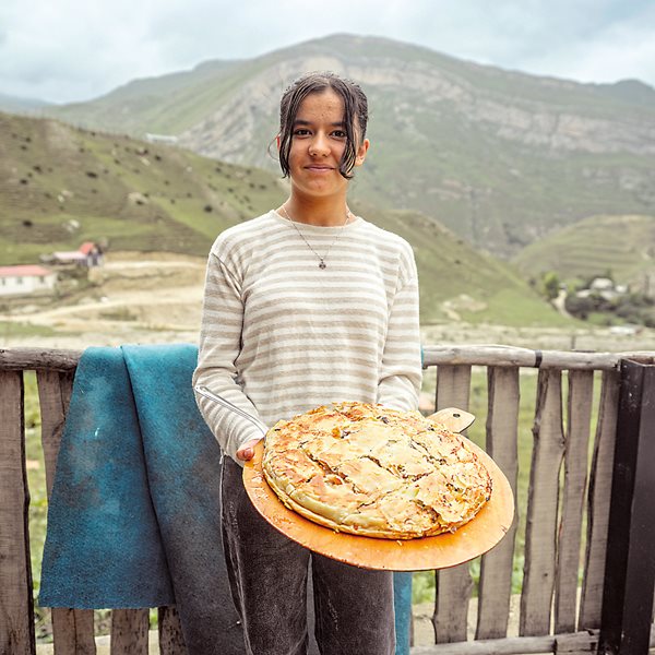 In the village of Laza, along the Transcaucasian Trail, a girl holds tskan, a traditional meat pie.