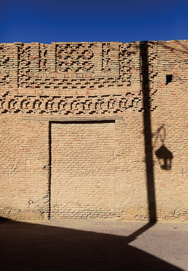 Sunlight illuminates a banded pattern of bricks over a bricked-in passageway in Ouled el-Hadef.