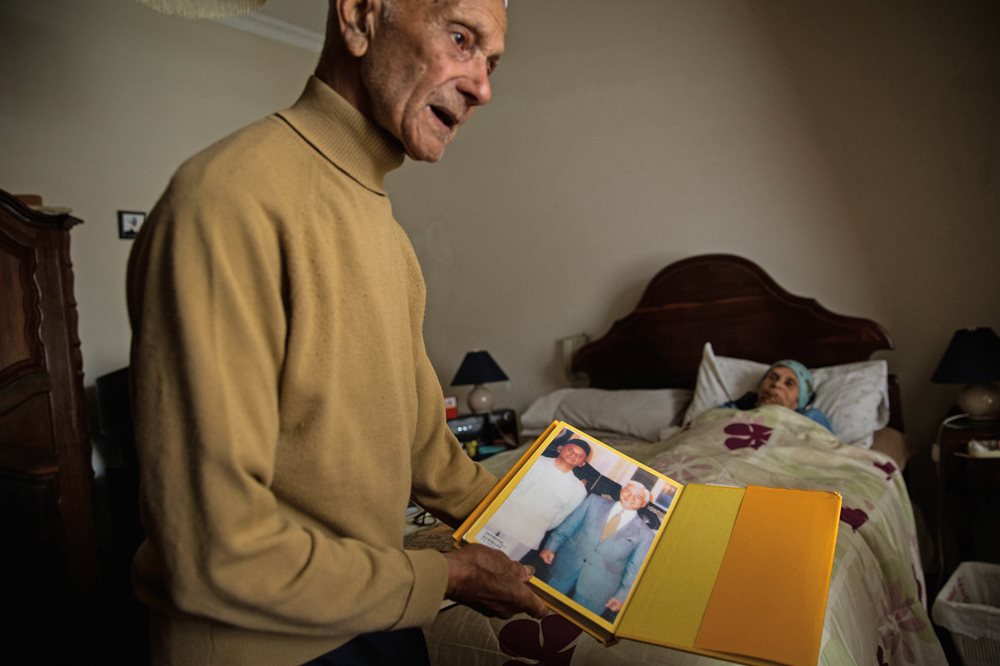 With his wife, Hawa, recovering from surgery at the couple&rsquo;s home in Kensington, Cape Town, Bapak Ismail Petersen, 94, shows photos explaining his founding, after the end of apartheid, of the Indonesian and Malaysian Seamen Club, which helps connect Cape Malay people to organizations and families in Malaysia. He remembers how his father would bring out kitabs some evenings for the family to study together.