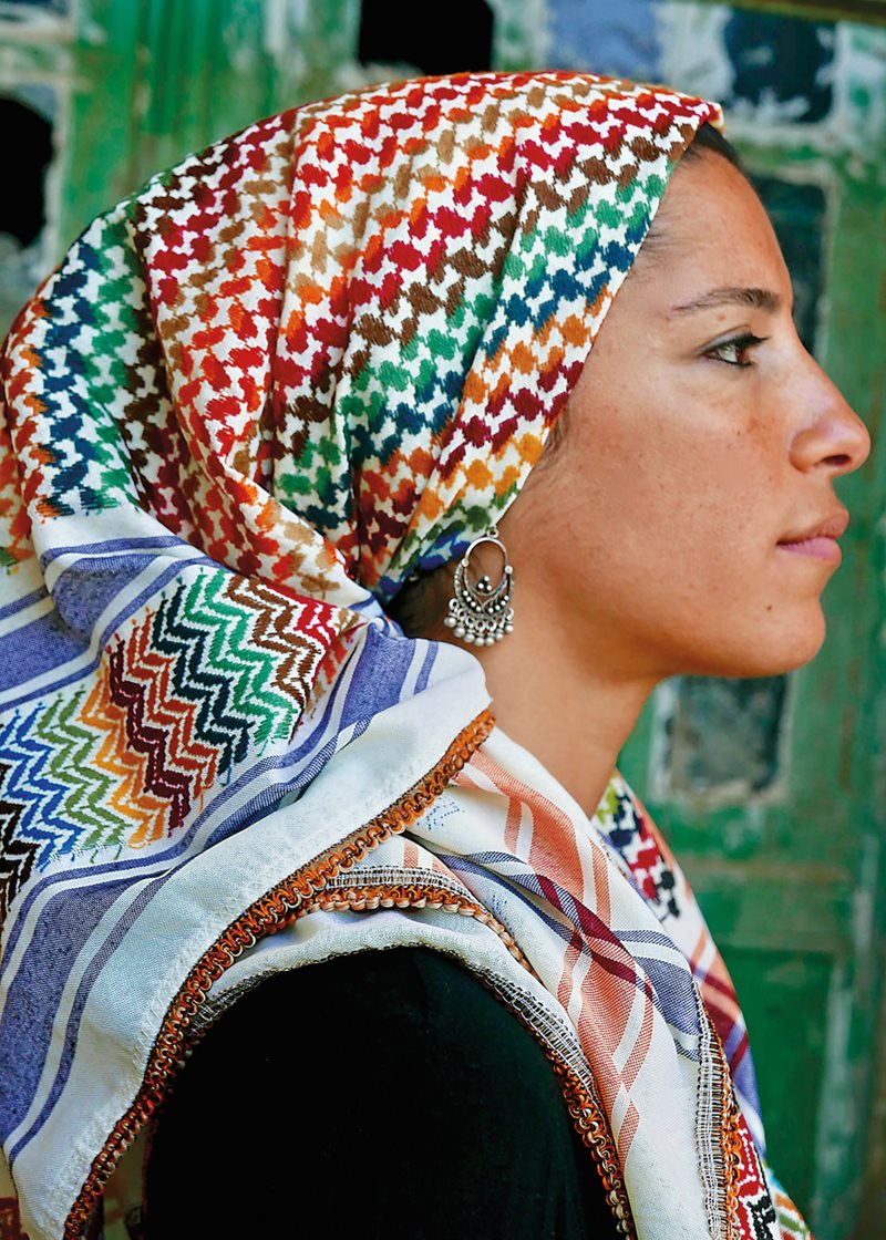 Meriem Ishawiyen wears a rainbow-colored kufiya produced by Hirbawi Textile Factory in Hebron.