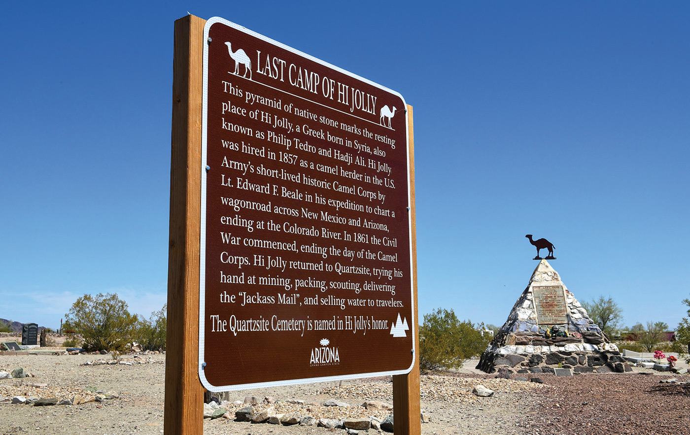 A historical marker and a pyramid-shaped memorial in Quartzsite, Arizona, keep alive the memory of Hi Jolly, who is described on the monument’s epitaph as “Cameldriver–Packer–Scout–Over thirty years a faithful aid to the US Government.