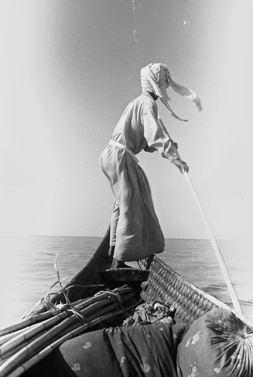 With the corners of his <i>shumagh</i>, or headscarf, catching the wind, Bin Thuqub poles Thesiger&rsquo;s tarada in 1953. Fed by the confluence of the Tigris and Euphrates Rivers, the marshes of southern Iraq are still the largest wetland ecosystem in the Middle East.