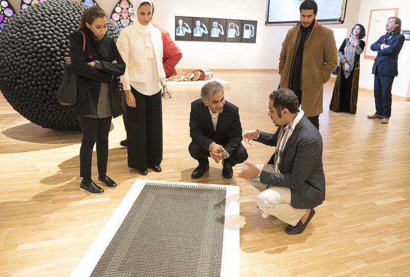At the “Phantom Punch” exhibit, Musaed Al-Hulis engages Tariq Al-Ghamdi, director of the King Abdulaziz Center for World Culture, about Al-Hulis’s work, “Dynamic,” a prayer rug made of motorcycle chains.
