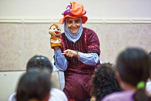 Donning a costume hat and a hand puppet, We Love Reading founder Rana Dajani engages children at a mosque in her home neighborhood of Tabarbour in Amman, Jordan. “I’ve always wanted to have a broader impact beyond the walls of the university,” says Dajani. She credits her inspiration for WLR to enthusiasm her own children expressed for after-school reading programs they attended in Des Moines, Iowa, while Dajani was earning her doctorate at the University of Iowa. 
