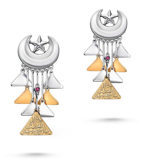 From “The Golden Age of Arabic Love Songs” collection, earrings—made of gold and sterling silver adorned with pink gem stones featuring Ottoman-inspired crescents and stars holding geometric motifs—are inscribed with the words of Emirati poet Salem Al-Khalidi, sung by Saudi Arabian artist Abdul Majeed Abdullah and composed by the Saudi Arabian Mamdouh Seif, Ya Tayyeb al Galb, “the one with the tender heart.”