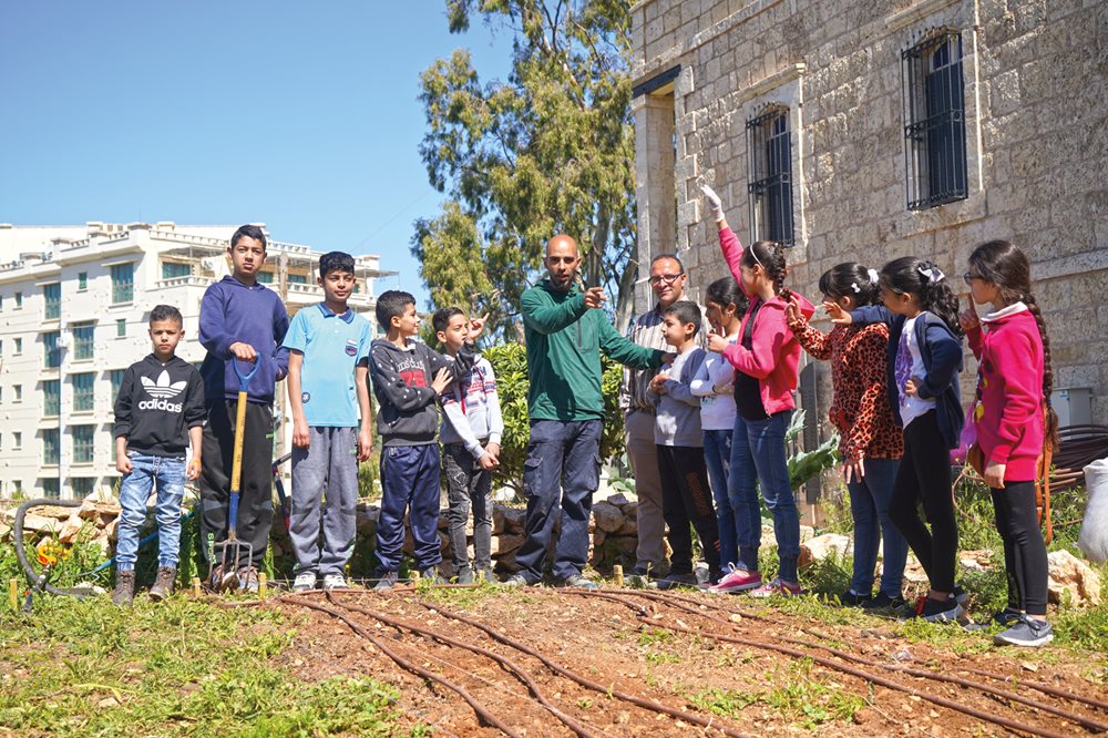 Led by resident landscape artist Mohammed Saleh, at center, children listen to his direction during his "Urban Farm" workshop.