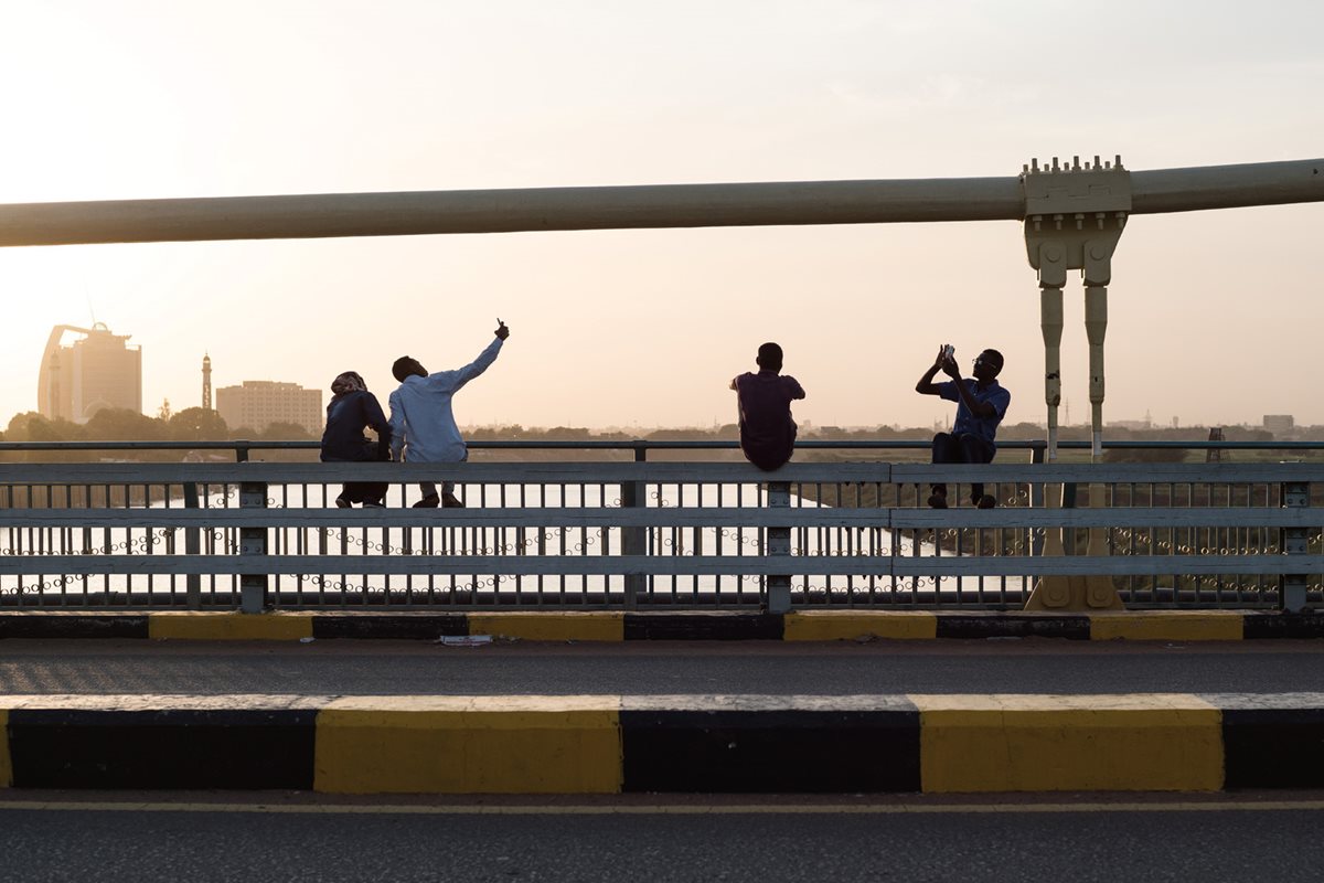 Sightseers snap selfies as they sit on a bridge over the Blue Nile between Khartoum and Tuti Island late in the afternoon.