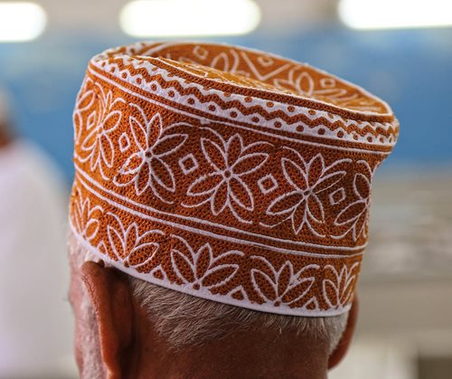 An Omani gentleman wears a kummah in a local fish market off the coast of the Arabian Sea.