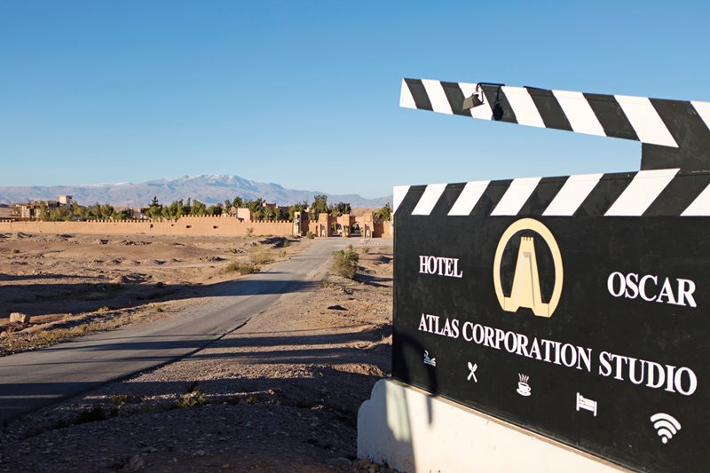 With the 20-hectare production studio in the background, at the edge of the desert beneath the Atlas Mountains, a sign decorated like a film director&rsquo;s clapboard advertises Atlas Studios&rsquo; hotel in Ouarzazate, Morocco.
